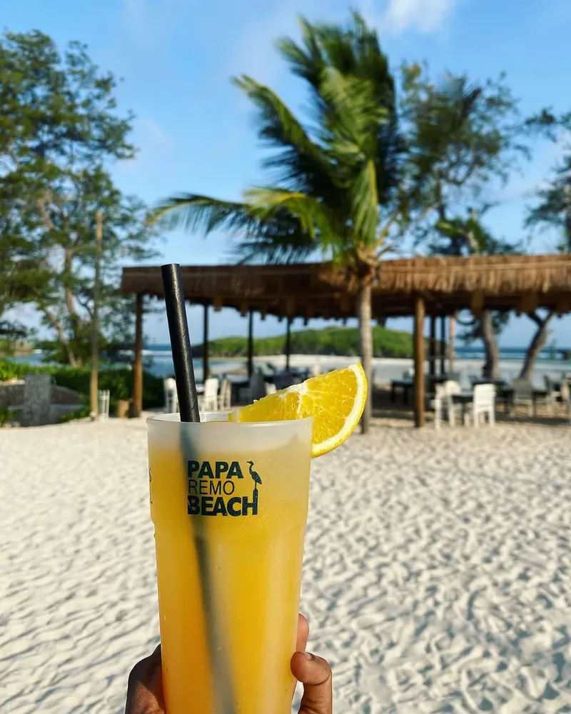 A cocktail in a Papa Remo Beach glass on the sand