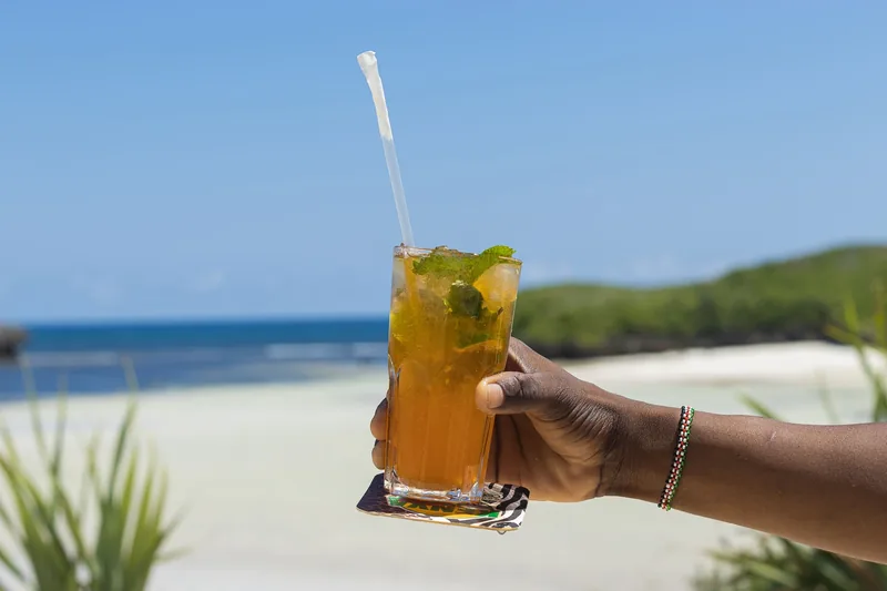 A cocktail held up against the bay