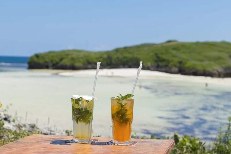 Two cocktails on a table above Love Island Beach