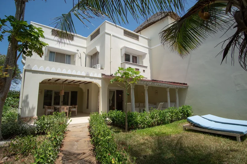 Villa Lollo: two-storey white villa exterior, lawn and sun loungers