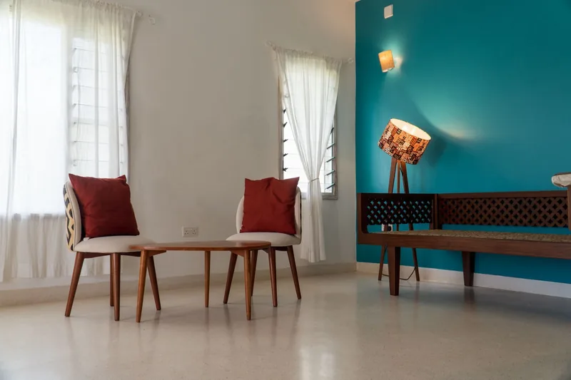Villa Sole's living room with a teal accent wall and red cushions